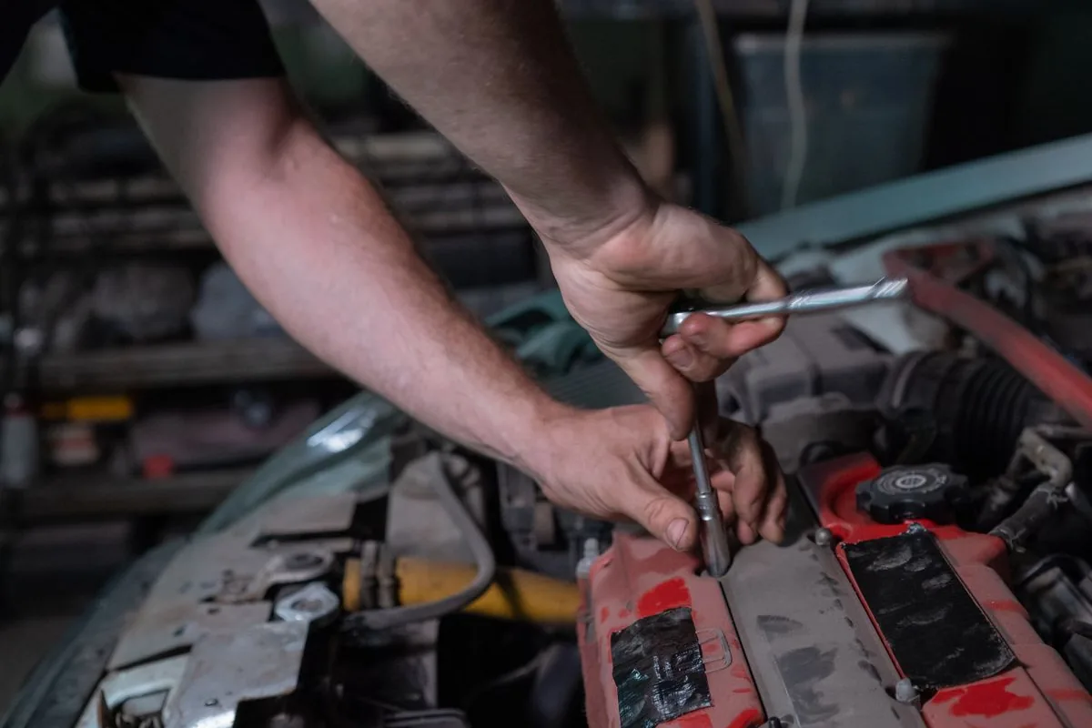Mechanic using tools to repair a car engine