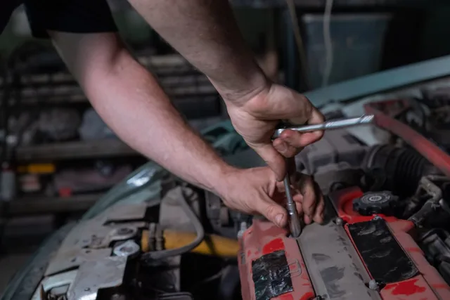 Mechanic using tools to repair a car engine