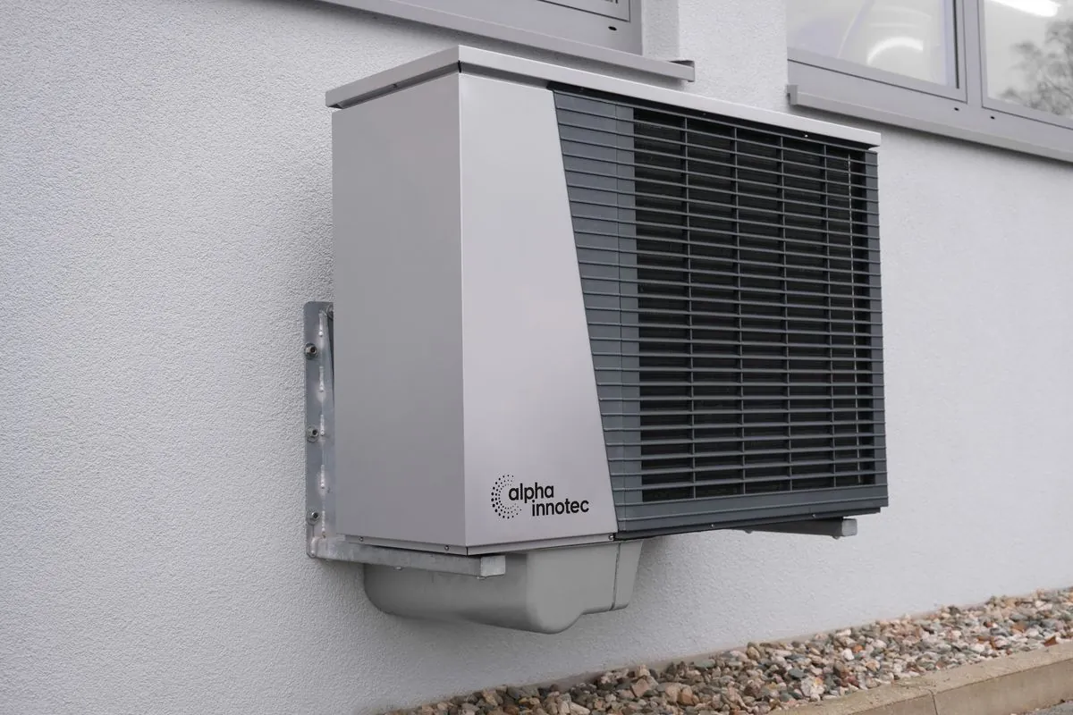 Outdoor heat pump unit mounted on a home exterior
