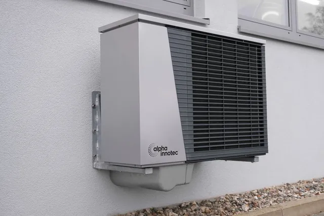 Outdoor heat pump unit mounted on a home exterior