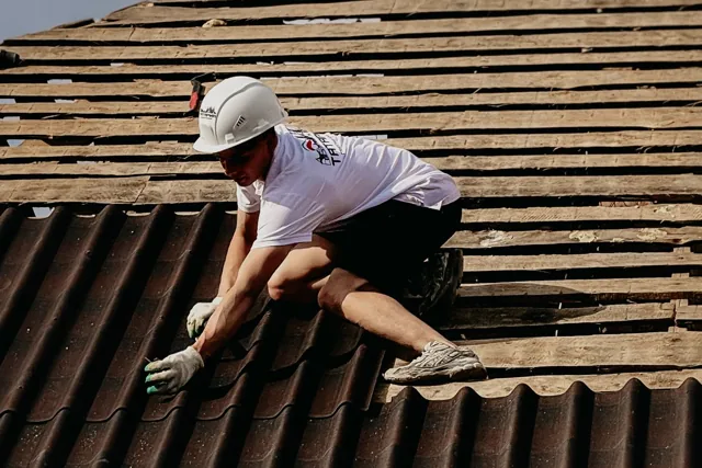 Roofer working on tiles on a sloped roof